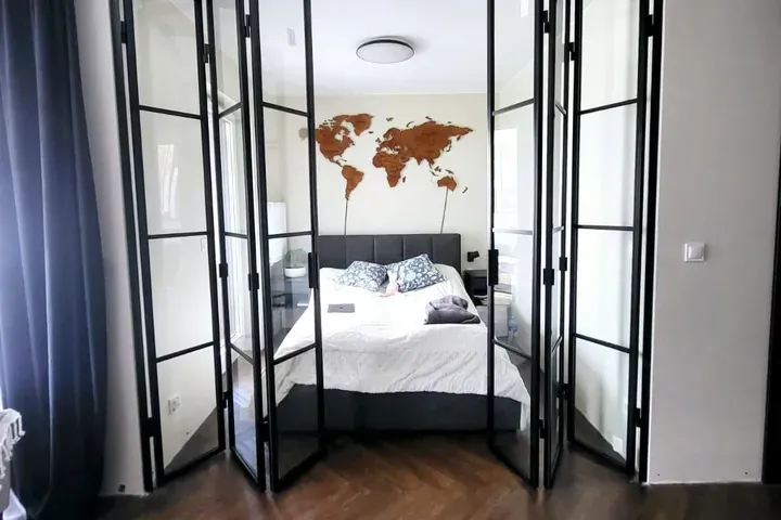 Black aluminium bifold doors folded open inside a London home